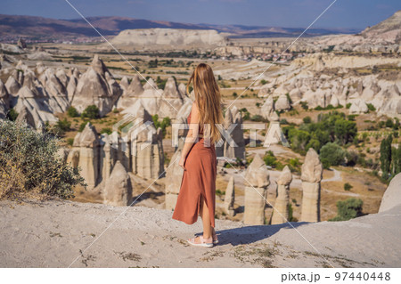 Young woman exploring valley with rock formations and fairy caves near Goreme in Cappadocia Turkey 97440448