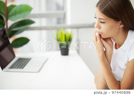 A young woman is suffering from a toothache in the office 97440896