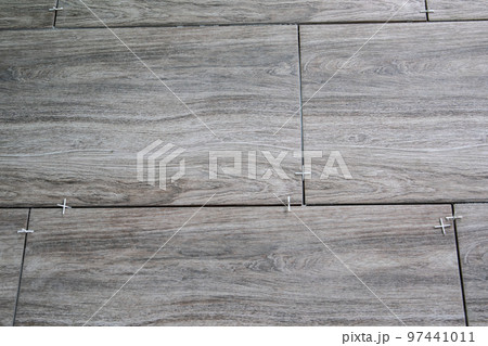 Laying ceramic tiles using plastic crosses. Renovation or repair concept Laying ceramic tiles using plastic crosses. Renovation or repair concept 97441011