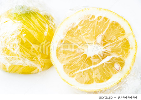 半分に切ってラップに包まれたレモン。(白バック) 半分に切ってラップに包まれたレモン。(白バック) 97444444