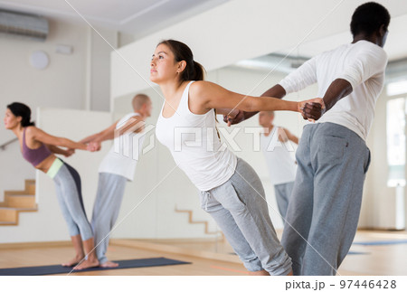 Woman practicing yoga with partner at studio Woman practicing yoga with partner at studio 97446428