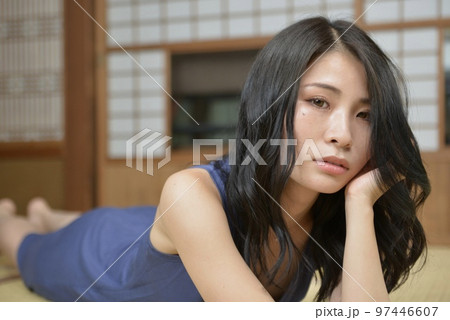 古民家の和室でくつろぐワンピースを着た若く美しい女性 97446607