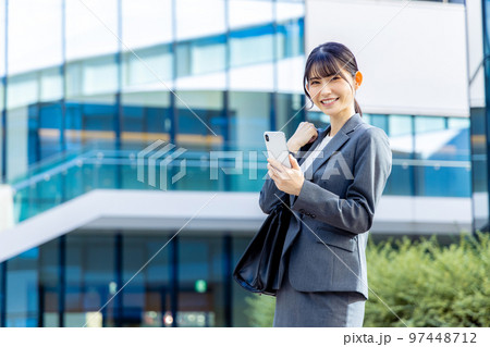 スマホを持つスーツの女性　撮影協力「LINK FOREST」 97448712