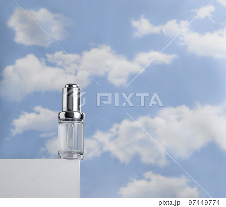 Transparent serum on white podium against cloudy blue sky. Concept of lightness of cosmetics Transparent serum on white podium against cloudy blue sky. Concept of lightness of cosmetics 97449774