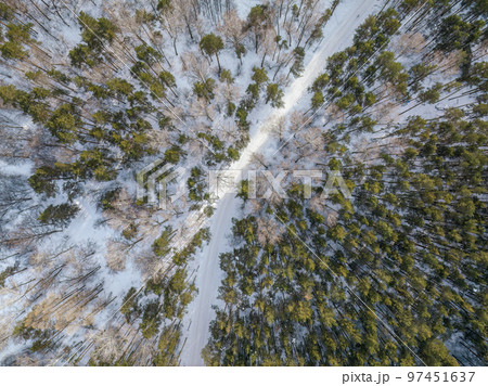 Flight over the winter mountains with road serpentine and pine forest. Top down view. Landscape photography 97451637