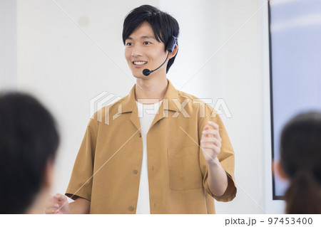 セミナー　ヘッドマイクを付けて話す男性 97453400