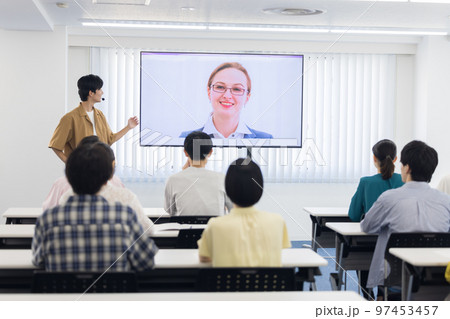 オンラインで繋がった外国人の話を聞く大学生 97453457