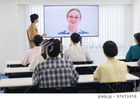 オンラインで繋がった外国人の話を聞く大学生 97453458