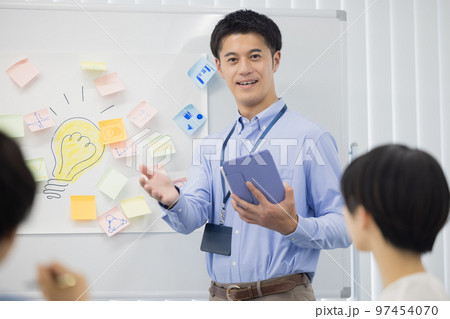 ミーティング タブレットを見ながら話す男性 ミーティング タブレットを見ながら話す男性 97454070