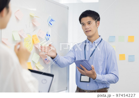 ミーティング　タブレットを見ながら話す男性 97454227