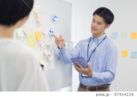 ミーティング タブレットを見ながら話す男性 ミーティング タブレットを見ながら話す男性 97454228