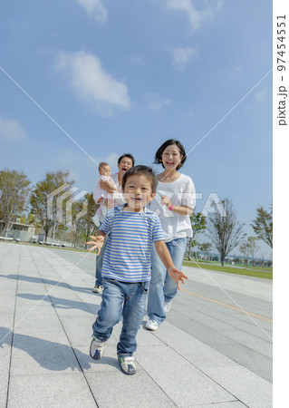 公園の遊歩道で遊ぶ4人家族 97454551