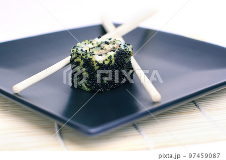 close-up of sushi and chopsticks on a black plate close-up of sushi and chopsticks on a black plate 97459087