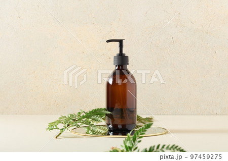 Pump amber glass bottle on beige background. Soap liquid, shampoo or shower gel packaging design 97459275