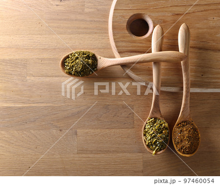 Wooden spoons with mixture of different spices on kitchen table Wooden spoons with mixture of different spices on kitchen table 97460054