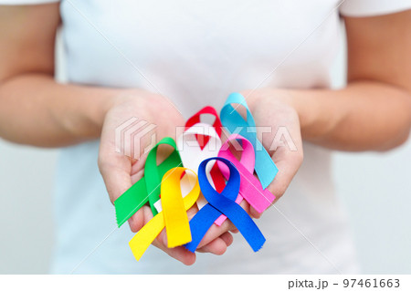 World cancer day, February 4. Hand holding blue, red, green, white, pink, navy blue and yellow ribbons for supporting people living and illness. Healthcare and Autism awareness day concept World cancer day, February 4. Hand holding blue, red, green, white, pink, navy blue and yellow ribbons for supporting people living and illness. Healthcare and Autism awareness day concept 97461663