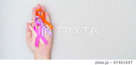 World cancer day, February 4. Hand holding orange, pink, peach and purple ribbons for supporting people living and illness. Healthcare and medical concept World cancer day, February 4. Hand holding orange, pink, peach and purple ribbons for supporting people living and illness. Healthcare and medical concept 97461697