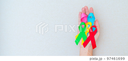 World cancer day, February 4. Hand holding blue, red, green, pink and yellow ribbons for supporting people living and illness. Healthcare and Autism awareness day concept 97461699