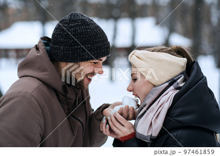 Valentines day outdoors celebration date ideas. Winter love story. Cold season dating for couples. Young couple in love play snowball, hugging and kissing in winter city street and park Valentines day outdoors celebration date ideas. Winter love story. Cold season dating for couples. Young couple in love play snowball, hugging and kissing in winter city street and park 97461859
