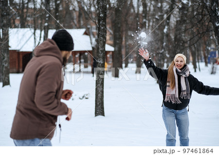 Valentines day outdoors celebration date ideas. Winter love story. Cold season dating for couples. Young couple in love play snowball, hugging and kissing in winter city street and park Valentines day outdoors celebration date ideas. Winter love story. Cold season dating for couples. Young couple in love play snowball, hugging and kissing in winter city street and park 97461864