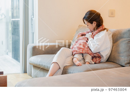 ソファーで赤ちゃんに授乳をするお母さん ソファーで赤ちゃんに授乳をするお母さん 97463804
