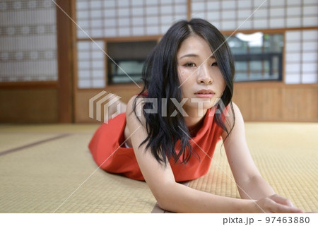 古民家の和室でくつろぐ赤いワンピースを着た若い女性 97463880