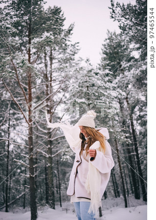 Active beautiful young woman in white clothes enjoying snowy winter forest Active beautiful young woman in white clothes enjoying snowy winter forest 97465544