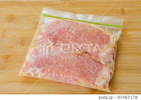ジップパックで漬けこむ豚ロース肉 97467178