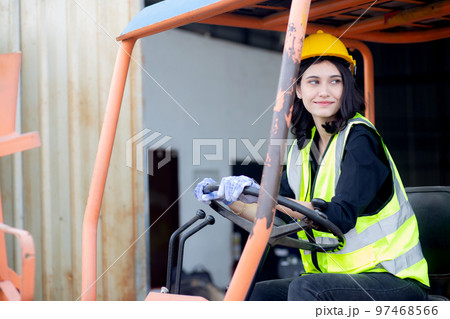 Young asian woman is foreman driving forklift at distribution warehouse. Young asian woman is foreman driving forklift at distribution warehouse. 97468566