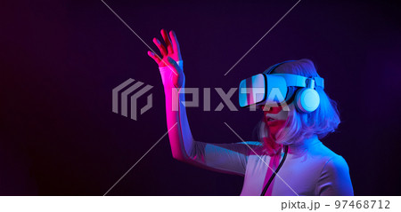 Woman in virtual reality goggle in neon colors. 97468712