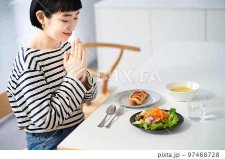 家のダイニングで食事を始める女性 97468728