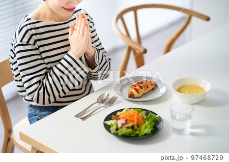 家のダイニングで食事を始める女性 97468729