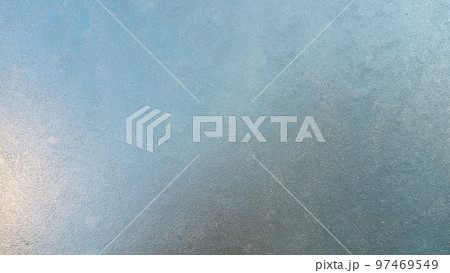 Abstract frosty pattern on glass, background texture. Frozen windshield. Granular structure of transparent ice. The sky is shining through. Abstract ice background. 97469549
