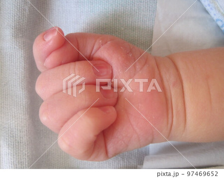 Newborn baby hand on the bedspread. 97469652