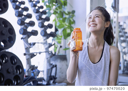 ジムで水分補給する若い女性 97470020
