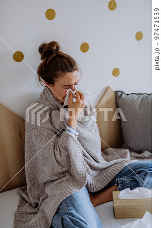 Sick woman sitting in bed, having a cold. 97471539