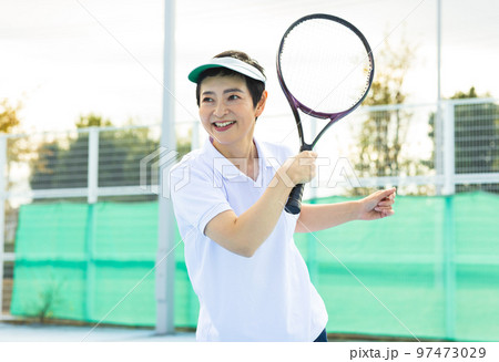 テニスを楽しむミドル女性 97473029
