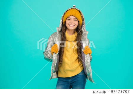 smiling teenage girl in padded or puffer jacket ready to spent winter holiday and vacation in comfort and warmth, childhood activity 97473707