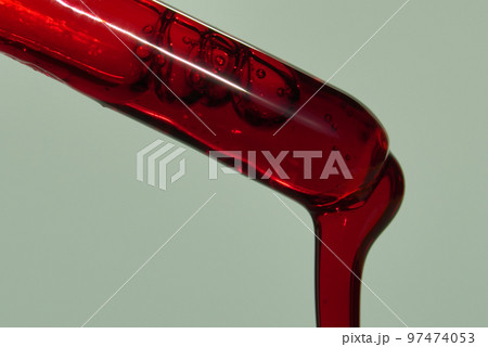 A drop of blood or other red liquid from a glass pipette. The concept of a blood test study with a copy space. High quality photo 97474053