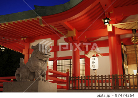 灯りに照らされた狛犬と神社の拝殿 / 初詣・二年参りのロケーションイメージ 97474264