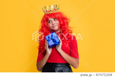 glad child in crown with gift box on yellow background glad child in crown with gift box on yellow background 97475209
