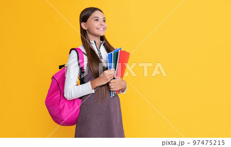 cheerful child with school backpack and workbook on yellow background cheerful child with school backpack and workbook on yellow background 97475215