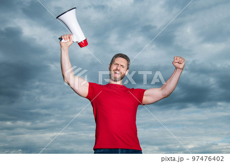 man in red shirt with loudspeaker on sky background 97476402