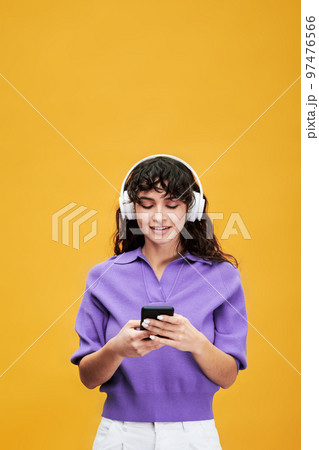 Brunette female student in headphones listening to music at break 97476566