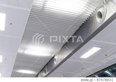 Ceiling mounted cassette type air conditioner and modern lamp light on white ceiling. duct air conditioner for home or office Ceiling mounted cassette type air conditioner and modern lamp light on white ceiling. duct air conditioner for home or office 97478031