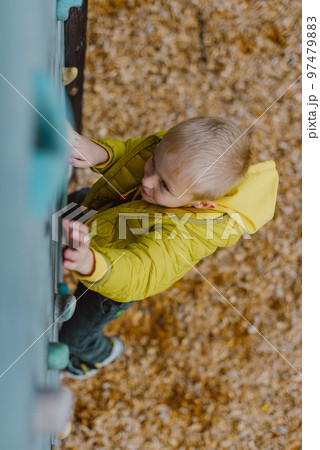 Boy At The Climbing Wall Without A Helmet, Danger At The Climbing Wall. Little Boy Climbing A Rock Wall Indoor 97479883