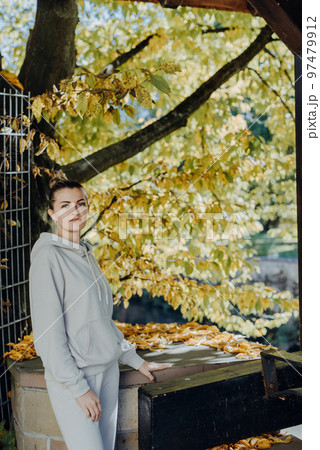 Beautiful elegant woman standing in autumn park with yellow leaves outdoor. Beauty Romantic Girl Outdoors enjoy autumn yellow leaves. Portrait of joyful woman in park during fall. Happy ng nature. Sun 97479912