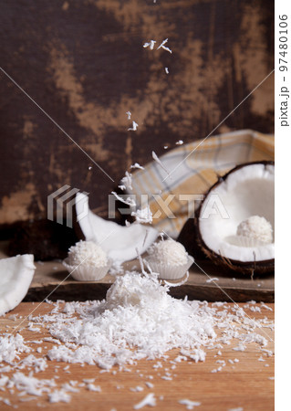 Close up of white candies and coconut with white pulp, coconut chip on wooden background.. Close up of white candies and coconut with white pulp, coconut chip on wooden background.. 97480106