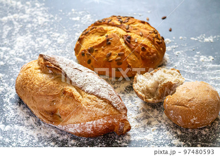 Bakery background with freshly baked bread and buns on flour kitchen table 97480593