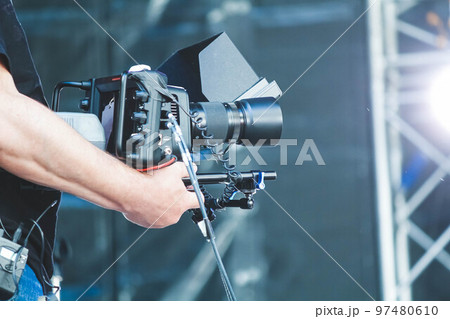 The operator with a video camera shoots a concert. Shooting video at the event. The operator with a video camera shoots a concert. Shooting video at the event. 97480610